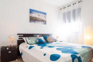 コラレホにあるMarina House Corralejo Centerのベッドルーム1室(大型ベッド1台、青と白のシーツ付)