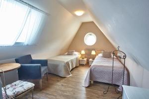 a attic room with two beds and a window at Penzion Kostnický dům in Tábor