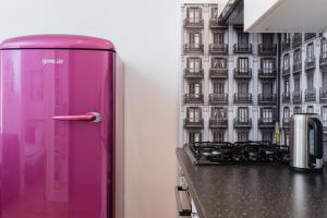- un réfrigérateur rose dans une cuisine à côté d'une cuisinière dans l'établissement Sawa Apartment, à Varsovie