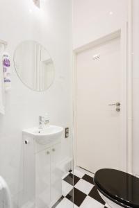 Baño blanco con lavabo y espejo en Sawa Apartment, en Varsovia