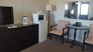 una habitación de hotel con microondas, mesa y sillas en Sunset motel, en Portage La Prairie