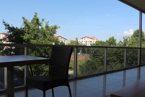einen Stuhl auf einem Balkon mit Blick auf die Bäume in der Unterkunft Helenapolis Otel in Altınova
