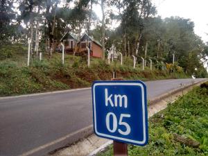 um sinal de limite de velocidade azul na berma de uma estrada em Chales Alpes Germanicos em Monte Verde