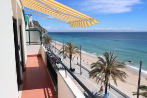 a view of the beach from the balcony of a building at Música Penthouse 360º in Sesimbra