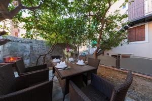a patio with a table and chairs and a fireplace at Riva Suite 1 in Komiža