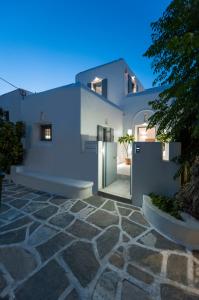 a white house with a door and a stone driveway at Villa Memories in Prodromos Paros