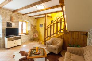 a living room with a couch and a tv at Villa Franz Krbune in Potpićan