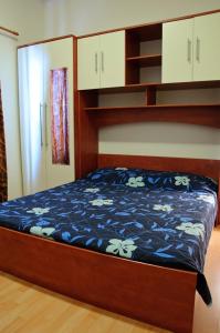 sypialnia z łóżkiem z niebieską kołdrą w obiekcie Apartmani Blaslov w mieście Kali