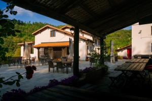 a patio with a table and chairs and a building at Agriturismo Cascina del Vai in Cairo Montenotte