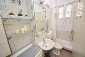 Un baño con lavabo, inodoro y espejo. en Apartment Viola, en Zadar