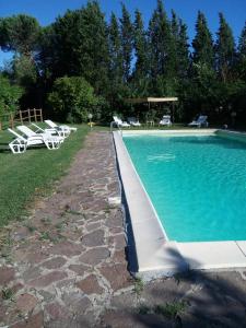 - une piscine avec des chaises et une table dans l'établissement Villa Poggio al Sole Bio Agriturismo private pool, à San Rocco a Pilli