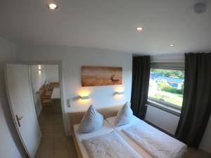 Un dormitorio con una cama blanca y una ventana. en Ferienhaus Goethestrasse, en Bad Harzburg
