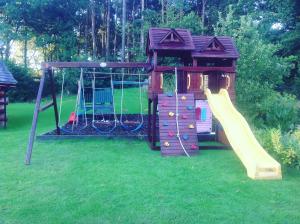 een speeltuin met een glijbaan en een speelhuis bij lyne view, log cabin in Carlisle
