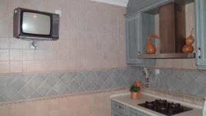 a kitchen with a sink and a tv on the wall at BLUE HOUSE by Stay in Alentejo in Vila Nova de Milfontes