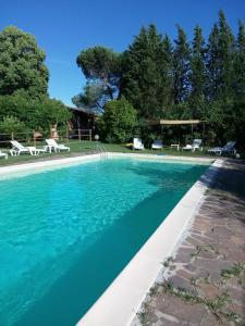 a swimming pool with blue water in a yard at Villa Poggio al Sole Bio Agriturismo private pool in San Rocco a Pilli