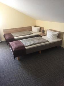 a room with two beds in a room at Pokoje Gościnne U Broni in Mielno