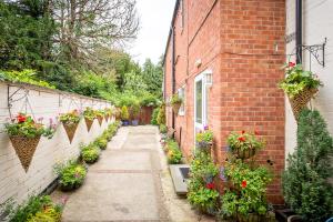 an alley with potted plants on the side of a brick building at Stratford Studios in Stratford-upon-Avon