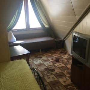 アドレルにあるGuest House Ilonaのベッド1台とテレビが備わる小さな客室です。