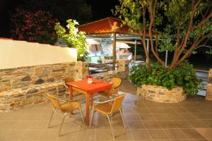a red table and chairs on a patio at Maria Studios in Neo Klima