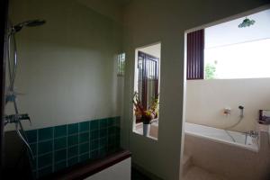 a bathroom with a shower and a tub and a sink at Yindee Stylish Guesthouse in Chiang Mai