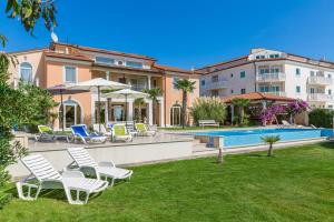 a villa with a swimming pool and lawnitures at Apartments Fiorido in Medulin