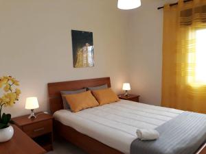 クアルテイラにあるSATÉLITE AC&Garagemのベッドルーム1室(ベッド1台、ナイトスタンド2台、ランプ2つ付)