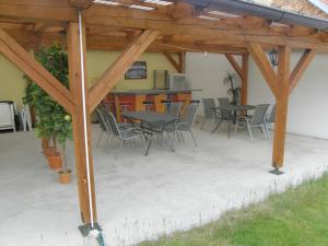 eine Terrasse mit Tischen und Stühlen unter einer hölzernen Pergola in der Unterkunft Penzion Cizku u Trebone in Třeboň