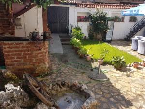 a garden with a hose attached to a house at Guest House Ginek in Ohrid