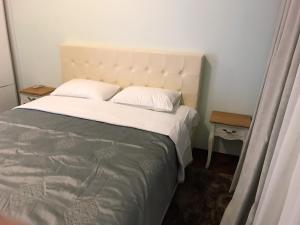 1 dormitorio con 1 cama grande con sábanas blancas en Viola Di Mare Apartments, en Budva