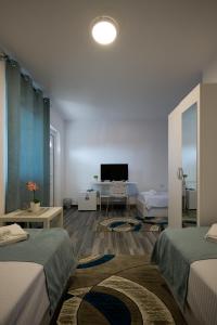 a room with two beds and a desk and a television at Bed & Breakfast Delikates in Stojakovo +47 photos