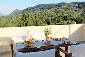 una mesa con comida y vistas a la montaña en Villa Antonia en Giannádes