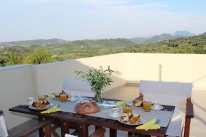 una mesa con platos de comida en el balcón en Villa Antonia en Giannádes