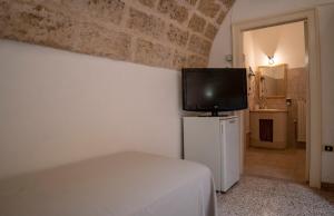 トリカーゼにあるB&B La vecchia Corteのベッドルーム1室(ベッド1台、壁にテレビ付)