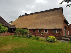 a large brick building with a thatched roof at Ferienwohnung Anna Frieda in Loxstedt
