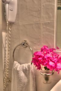 a bathroom with pink flowers and a towel at Ostria in Naousa +62 photos