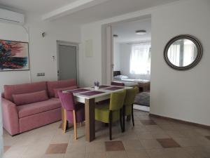 uma sala de estar com uma mesa e cadeiras e um sofá em Roses em Bihać