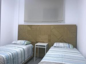 サンルーカル・デ・バラメダにあるPiso en la playa de Sanlucarのベッド2台が隣同士に設置された部屋です。