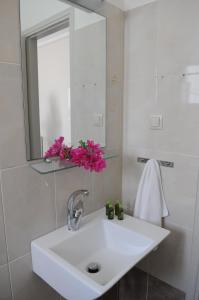 a bathroom with a white sink and a mirror at Alykes in Marmari