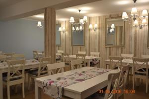 a dining room with tables and chairs and mirrors at Willa Faustynka in Nałęczów