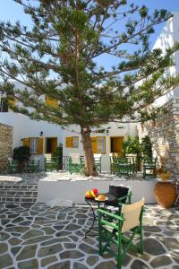 a table and chairs under a tree on a patio at Ostria in Naousa
