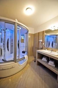 een badkamer met een groot bad en een wastafel bij Villa Skadarlija in Belgrado