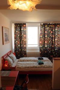 a bedroom with two beds and a window with curtains at Panorama Prague Castle in Prague