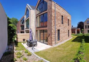 a brick house with an umbrella in the yard at Ostsee Perle 35 in Heiligenhafen