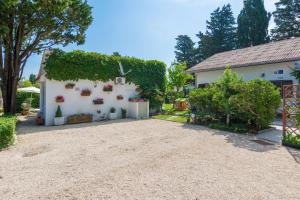 a white house with plants and a driveway at Apartments Kiara Sabunike 836 in Privlaka