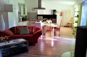 uma sala de estar com um sofá vermelho e uma cozinha em Grooten Wiebkings em Schneeren