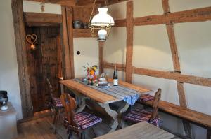 een eetkamer met een houten tafel en stoelen bij La Maison 1603 in Hunawihr