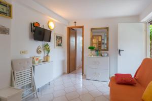 a living room with a couch and a tv on the wall at Apartments Kiara Sabunike 836 in Privlaka