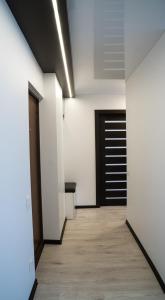 een hal met witte muren en een zwarte deur bij Welcome Centre Apartaments in Klaipėda