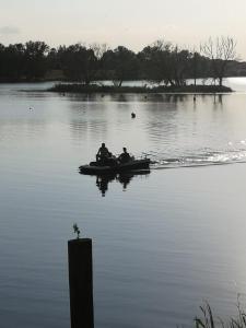 tres personas en un barco en un lago en Ferienhäuser Pannier I und oder II, en Gartow