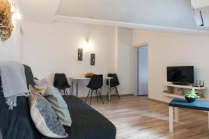 a living room with a couch and a tv at Balabanov White in Varna City